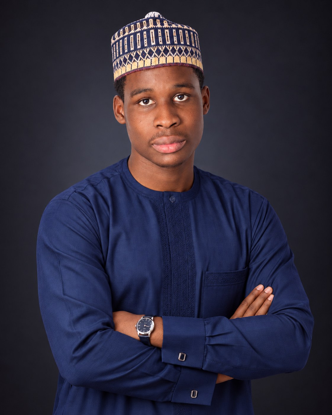 Studio portrait of HardwiredNG founder Nabil Ismail Abdulkadir wearing a navy kaftan and patterned cap